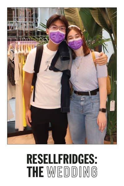 A couple wearing purple masks stands together, posing for a photo in front of a clothing rack and large plants. Caption: "RESELLFRIDGES: THE WEDDING.